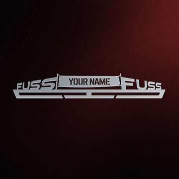 Fuss Fuss Éremtartó - Egyedi Éremakasztó fém kivitelben, középen testreszabható névtáblával, sötét háttérrel.